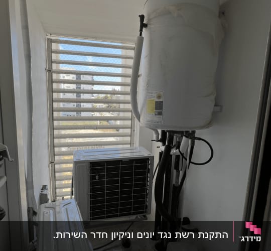 מזגן ומיכל מים במסתור כביסה עם רשת